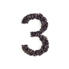 Number 3 made from sunflower seeds. Alphabet made from sunflower seeds. White background