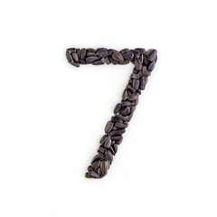 Number 7 made from sunflower seeds. Alphabet made from sunflower seeds. White background