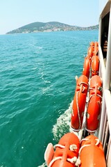 Bright orange lifebuoys aboard a sea ferry