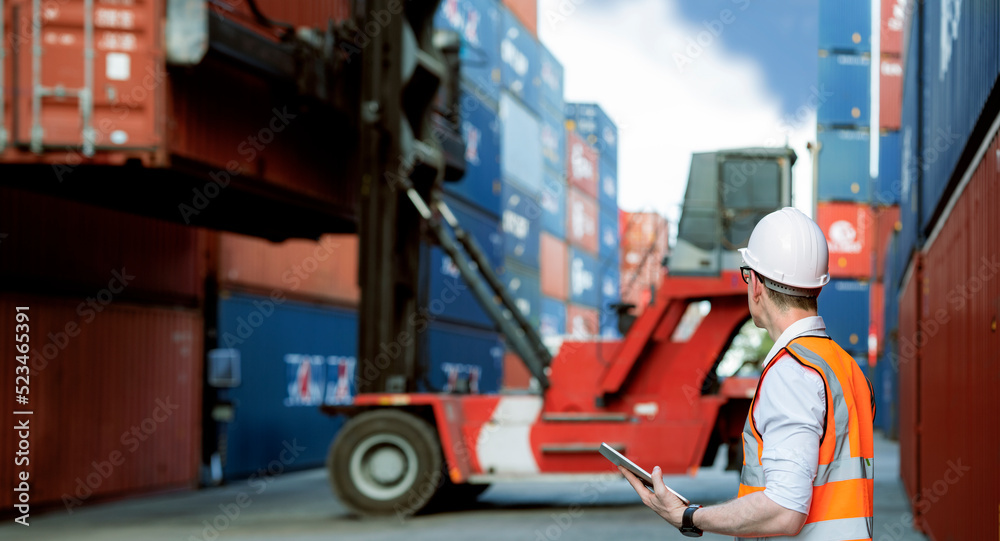 Fototapete industrial worker is controlling container loading by walkie talkie in import export business