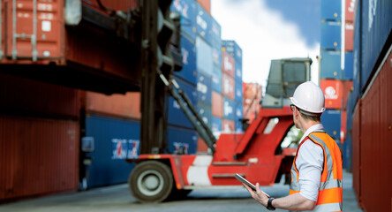 industrial worker is controlling container loading by walkie talkie in import export business
