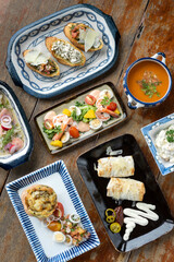 selection of many different tapas on rustic wood table