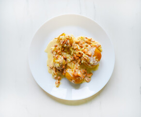 A homemade delicious meal made of potato and mushrooms with the sauce with the selective focus.