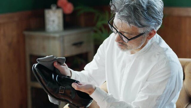 60p　家で靴磨きするシニア男性
