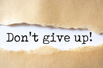 Do not give up, text on white paper on torn paper background