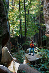 woman traveler with backpack walking by trail in canyon