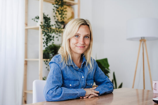 Smiling blond businesswoman at desk in home office