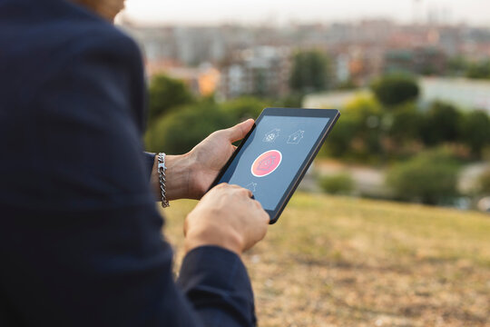 Businessman using home automation app on tablet PC at sunset