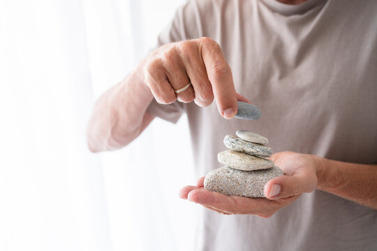 Man stacking stones on hand at home