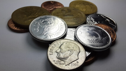 Dollar dime coin, with Franklin D. Roosevelt’s image, with a collection of various old coins on a white background.