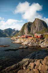 Fototapeta na wymiar Panorama of Hamnoy in Lofoten in Norway (Reine). Red cabins close to the water at sunset landscape