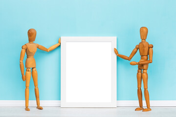 Poster mockup, vertical white transparent picture frame presented by two artist's mannequins in...