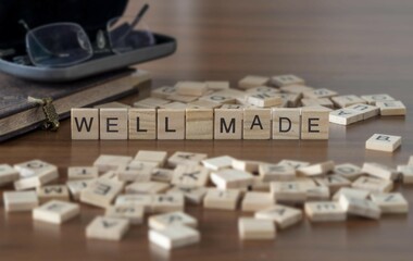 well made word or concept represented by wooden letter tiles on a wooden table with glasses and a book