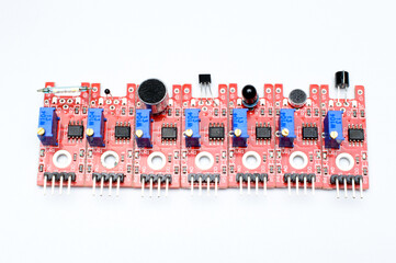 Arduino DIY modules on a white background. Selective focus. Red PCB. Blue potentiometers....