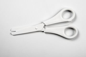 White matte scissors on a white background. Stationery and education