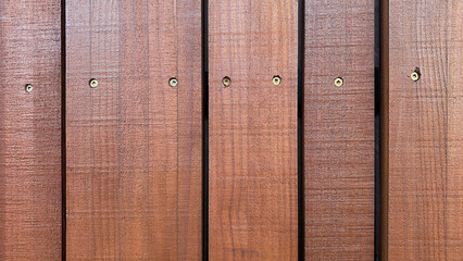 Close-up of cedar wood cladding wall planks with visible screw heads