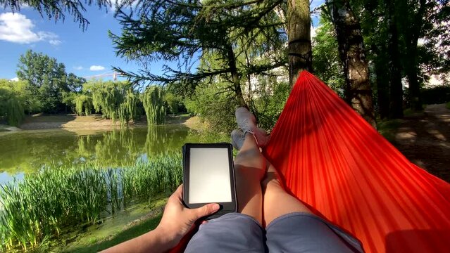 point of view woman laying down on the hammock reading book