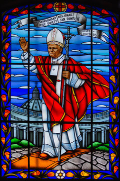 Baruny, Belarus - July 16, 2022: Colored stained-glass window in the church on the window - the image of Pope John Paul II