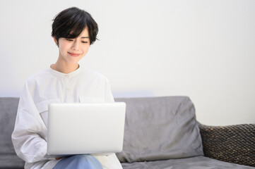 Woman relaxing on sofa while using computer