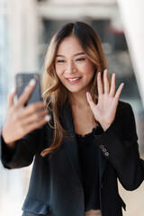 Businesswoman having a video call on smartphone while discussion with business partner