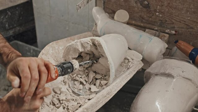 High angle shot of unrecognizable man removing plaster used to cast plastic socket for leg prosthesis