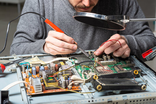 man repairing or soldering an electronic appliance or product. close up image
