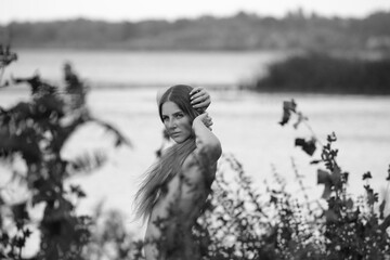 Beautiful naked woman in harmony with nature in black and white