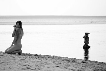 Pretty naked woman at the beach in black and white