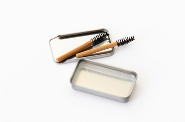 Two bamboo brow brushes and brow styling soap in a metal box. Cosmetic set