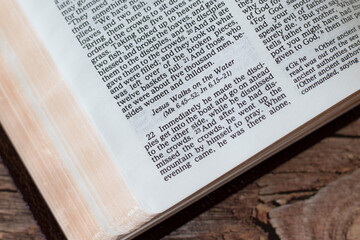 Jesus Christ walks on water verses in an open Holy Bible Book. A closeup.