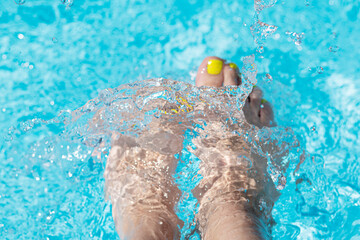 Female with perfect yellow pedicure over a pool. Vacation pericure. Female bare feet in a blue...