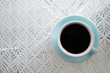 A americano coffee is served on the white table. - 523495564