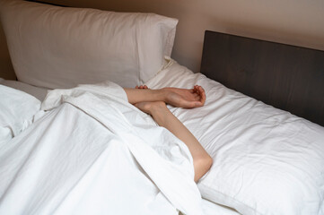 Fototapeta na wymiar Woman sleeping in the bed under white sheet.