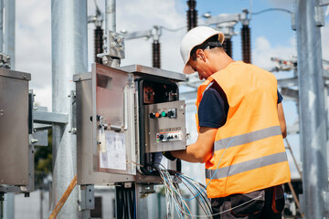 Adult electrical engineer inspect the electrical systems at the equipment control cabinet....