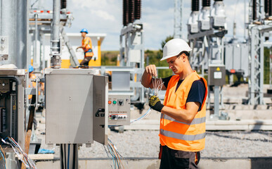 Adult electrical engineer inspect the electrical systems at the equipment control cabinet....