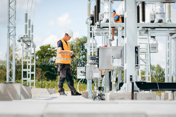 Adult electrical engineer inspect the electrical systems at the equipment control cabinet....