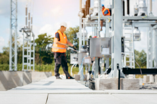 Adult electrical engineer inspect the electrical systems at the equipment control cabinet. Installation of modern electrical station