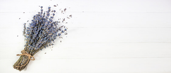 Bouquet of dried lavender on a white wooden background. Banner, flat lay, place for text.