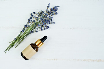 Lavender oil in glass bottles and a bouquet of fresh lavender. Flat lay, place for text.