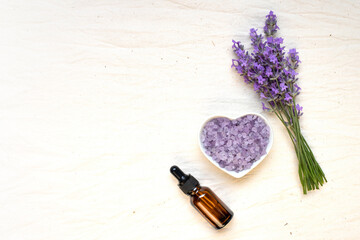Obraz na płótnie Canvas A set of a bouquet of natural lavender, a bottle of oil and lavender salt. Flat lay, place for text.