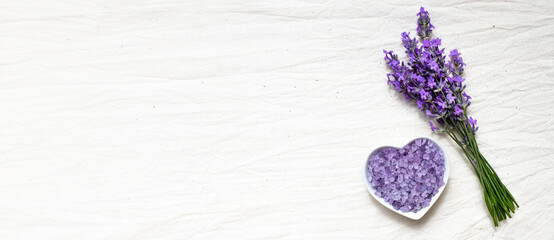 Heart-shaped lavender spa salt with natural lavender bouquet. Skin care concept. Banner, flat lay,...