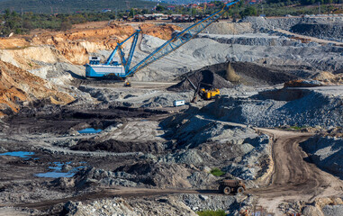Panoramic aerial view of coal mine. Open pit mine industry, big yellow mining truck for coal quarry. Open coal mining anthracite mining. Pit on coal mining by open way. 