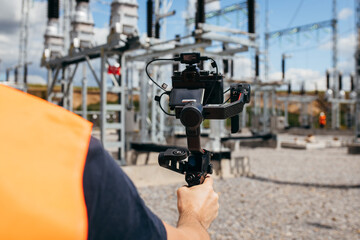 Adult videographer shoots a video about a modern power plant. Close up