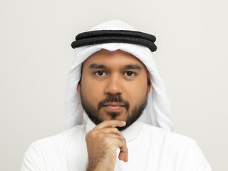 Portrait of arabic man with kandura dress on isolated white background. Arab business people thinking.