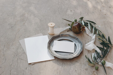 Summer, Mediterranean wedding stationery. Business card, invitation mock ups. Vintage silver plate in sunlight. Pomegranate fruit, ribbon, olive tree branches. Rosh Hashanah holiday. Autumn stationery
