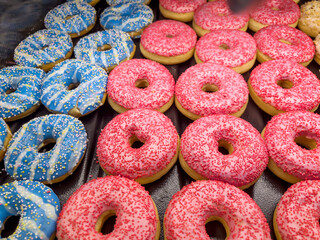 Pink and blue donuts in bakery shop