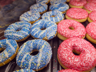 Pink and blue donuts in bakery shop