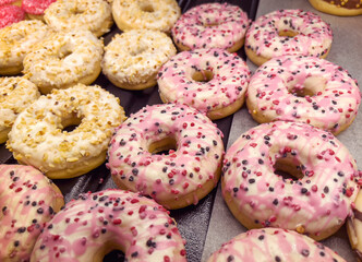 Assorted pink donuts in bakery shop