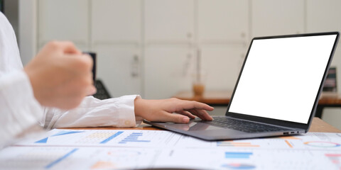 Focused businesswoman using laptop computer at bright modern office..