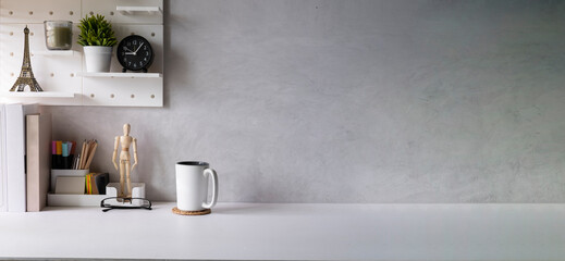 Home office desk with books, coffee cup, houseplant and stationery on white table. Copy space for your advertise text.
